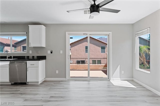 5116 Iron Crossing Ave, Las Vegas, NV 89131 - kitchen featuring stainless steel dishwasher, a sink, white cabinetry, and light wood-style floors