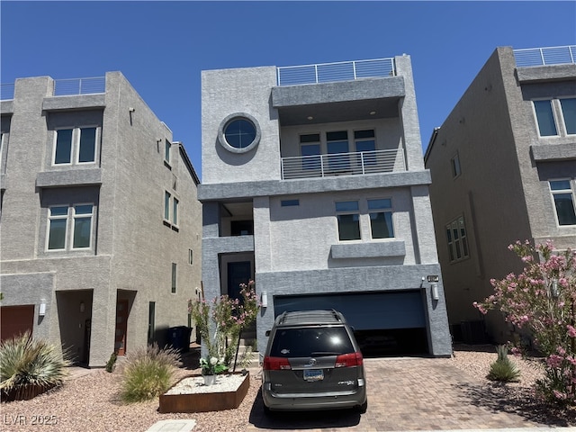 8076 Haywood Estate Ave, Las Vegas, NV 89113 - contemporary house featuring an attached garage, stucco siding, decorative driveway, and a balcony