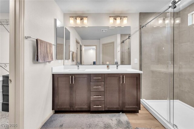 8076 Haywood Estate Ave, Las Vegas, NV 89113 - bathroom featuring a tile shower, double vanity, a spacious closet, and baseboards
