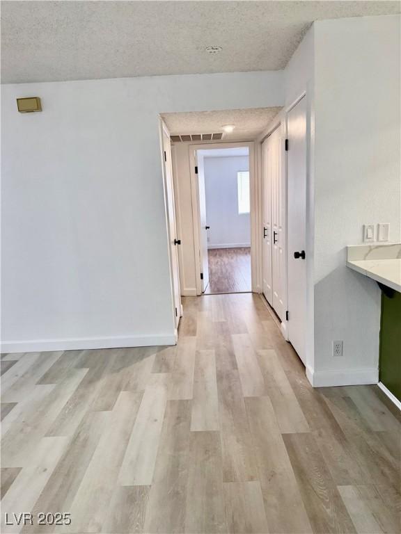 1320 Driscoll Dr Unit 202, Las Vegas, NV 89128 - hall featuring light wood-type flooring, a textured ceiling, and baseboards