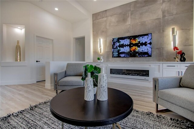 10025 Netherton Dr, Las Vegas, NV 89134 - living area with a glass covered fireplace, light wood finished floors, baseboards, and recessed lighting
