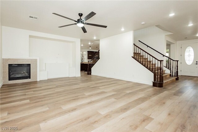25 Blue Valley Dr, Henderson, NV 89002 - unfurnished living room featuring stairway, light wood-style flooring, ceiling fan, a glass covered fireplace, and recessed lighting