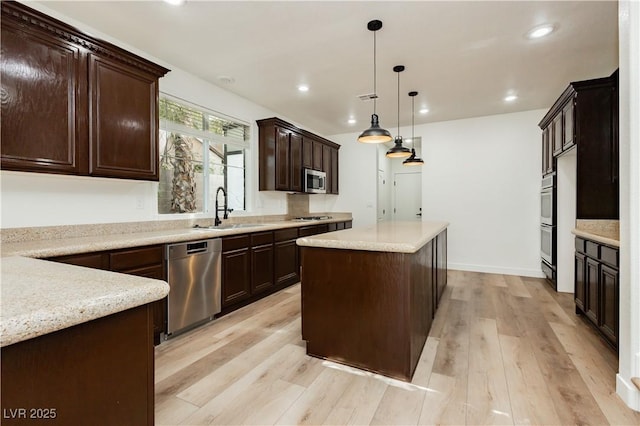 25 Blue Valley Dr, Henderson, NV 89002 - kitchen with stainless steel appliances, a sink, a kitchen island, light wood finished floors, and dark brown cabinetry