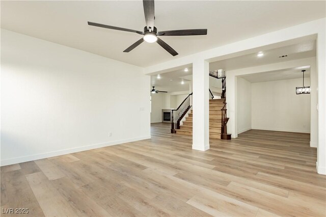 25 Blue Valley Dr, Henderson, NV 89002 - unfurnished living room with ceiling fan, stairs, light wood finished floors, and baseboards