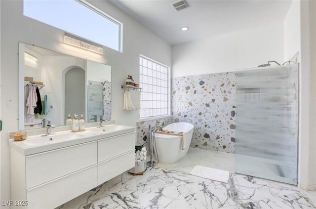3064 Azure Bay St, Las Vegas, NV 89117 - full bath featuring a walk in shower, double vanity, marble look tiles, and a freestanding tub