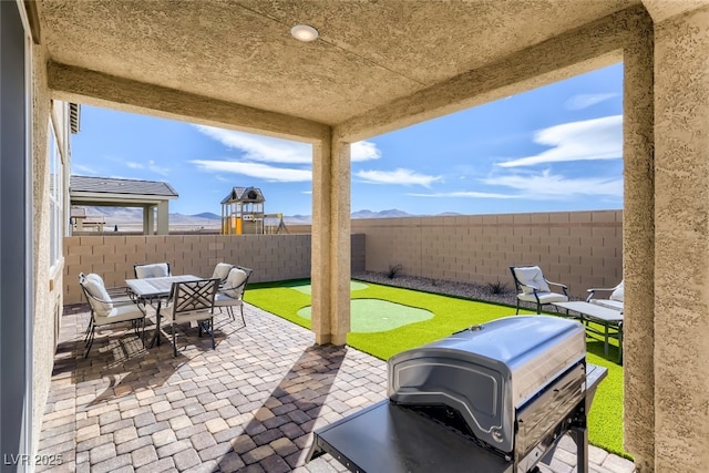 2417 Fasano St, Henderson, NV 89044 - fenced backyard with a putting green, a patio area, outdoor dining area, and a mountain view
