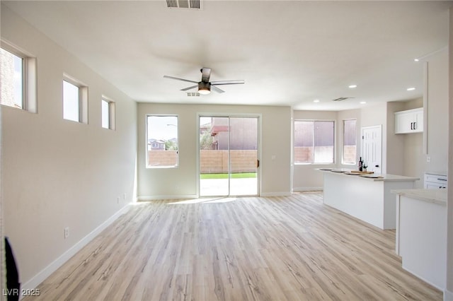 6387 Azurelyn Ave, Las Vegas, NV 89122 - unfurnished living room featuring light wood-style flooring, a ceiling fan, baseboards, and recessed lighting