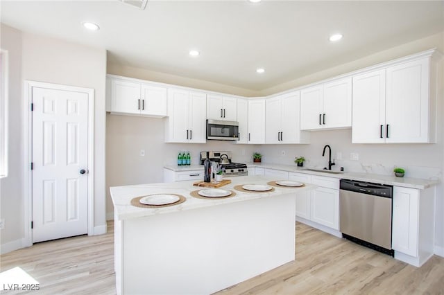 6387 Azurelyn Ave, Las Vegas, NV 89122 - kitchen featuring stainless steel appliances, a sink, light wood-type flooring, white cabinetry, and recessed lighting