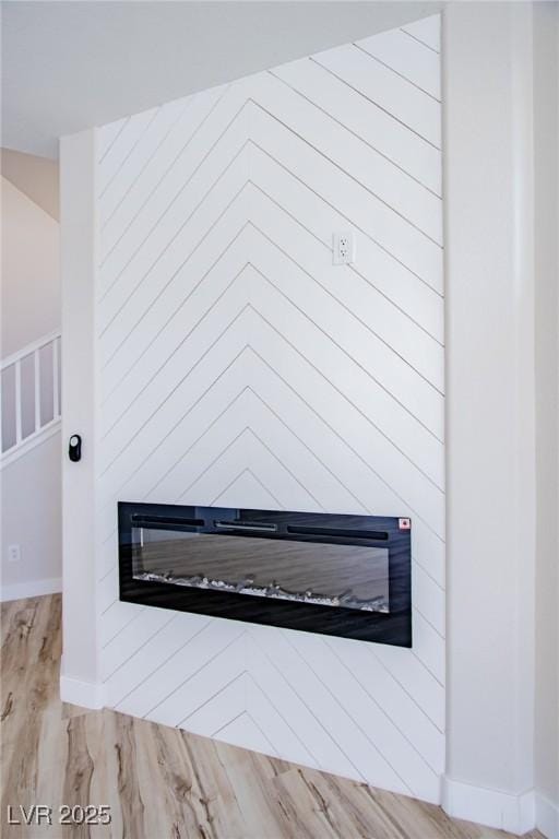 6387 Azurelyn Ave, Las Vegas, NV 89122 - detailed view of a glass covered fireplace, wood finished floors, and baseboards