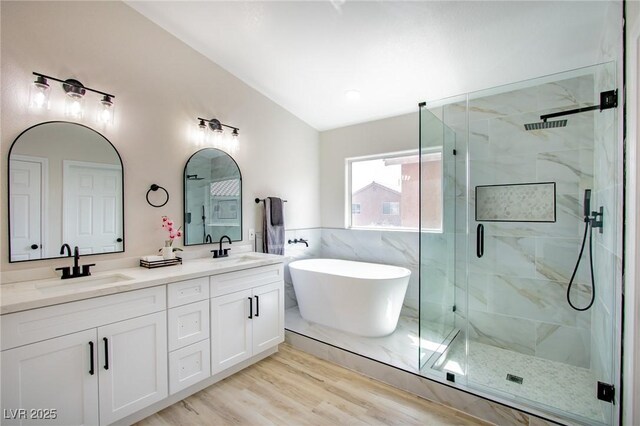 6387 Azurelyn Ave, Las Vegas, NV 89122 - full bath featuring vaulted ceiling, a marble finish shower, a soaking tub, double vanity, and wood finished floors