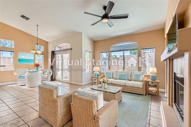 2889 Anteres St, Las Vegas, NV 89117 - living room with light tile patterned flooring, a glass covered fireplace, ceiling fan, baseboards, and high vaulted ceiling