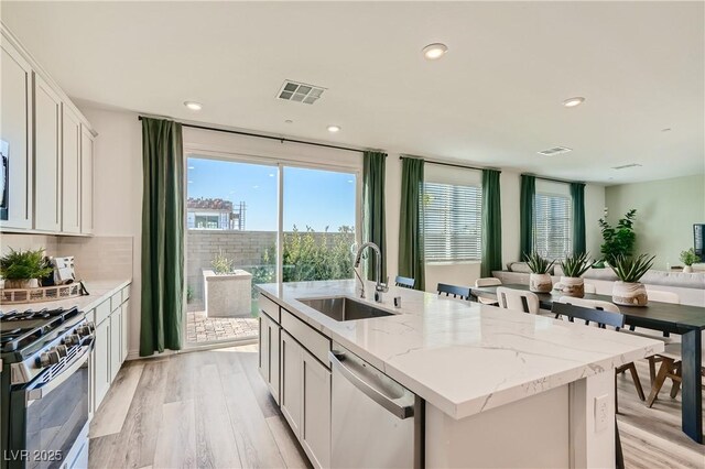 9564 Archer Peak Ct, Las Vegas, NV 89143 - kitchen featuring a sink, appliances with stainless steel finishes, open floor plan, light wood finished floors, and recessed lighting