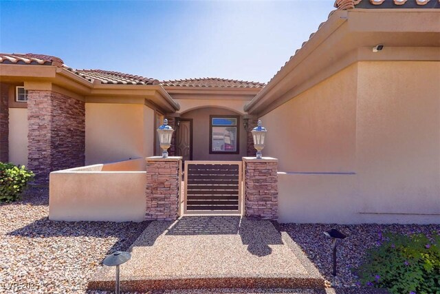 271 E Shelbourne Ave, Las Vegas, NV 89123 - property entrance with a gate, stucco siding, and a tile roof