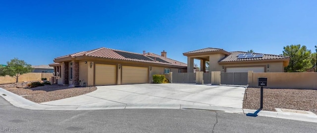 271 E Shelbourne Ave, Las Vegas, NV 89123 - view of front of house featuring an attached garage, a fenced front yard, roof mounted solar panels, and stucco siding