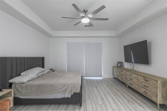 271 E Shelbourne Ave, Las Vegas, NV 89123 - bedroom with a tray ceiling, light wood-type flooring, a ceiling fan, and baseboards