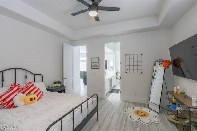 271 E Shelbourne Ave, Las Vegas, NV 89123 - bedroom featuring a tray ceiling, light wood-style floors, baseboards, a ceiling fan, and ensuite bathroom