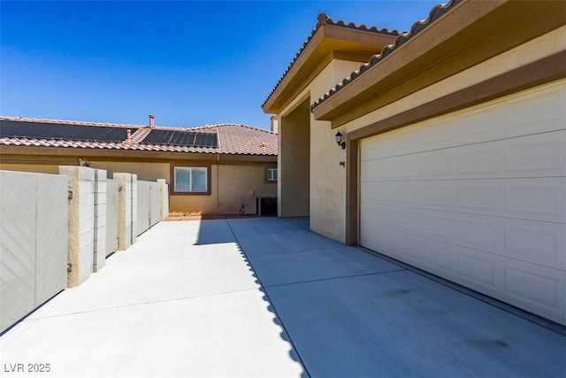 271 E Shelbourne Ave, Las Vegas, NV 89123 - view of side of property featuring stucco siding, a tiled roof, roof mounted solar panels, and central AC unit