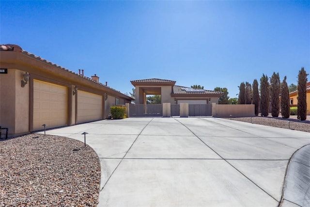 271 E Shelbourne Ave, Las Vegas, NV 89123 - mediterranean / spanish-style house featuring concrete driveway, stucco siding, a garage, a tiled roof, and roof mounted solar panels