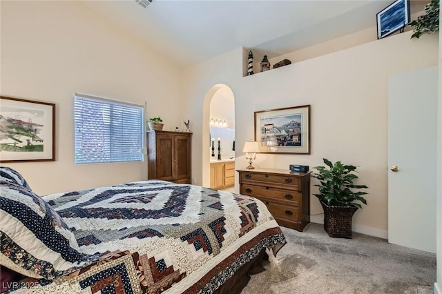 3629 Ferrell St, North Las Vegas, NV 89032 - bedroom with light carpet, arched walkways, vaulted ceiling, and connected bathroom