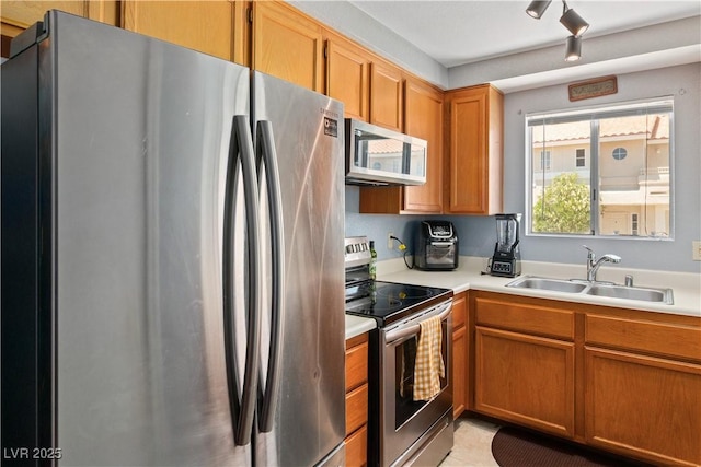 2200 Highpointe Dr Unit 202, Laughlin, NV 89029 - kitchen with appliances with stainless steel finishes, a sink, light countertops, light tile patterned floors, and brown cabinetry