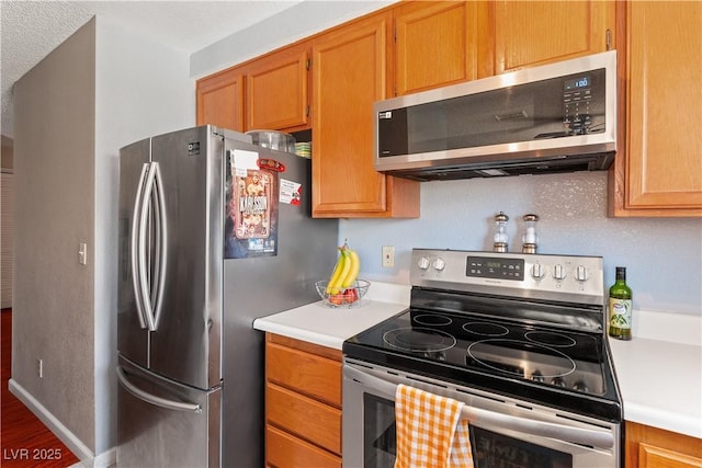 2200 Highpointe Dr Unit 202, Laughlin, NV 89029 - kitchen featuring appliances with stainless steel finishes, light countertops, wood finished floors, and brown cabinetry
