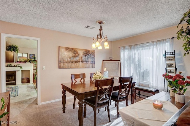 7109 Deepriver Cir, Las Vegas, NV 89129 - dining area featuring carpet flooring, a textured ceiling, a fireplace, a chandelier, and baseboards