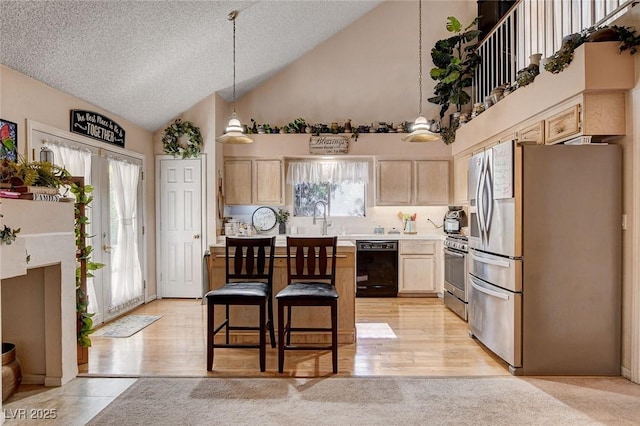 7109 Deepriver Cir, Las Vegas, NV 89129 - kitchen featuring appliances with stainless steel finishes, light brown cabinetry, light countertops, high vaulted ceiling, and a kitchen bar