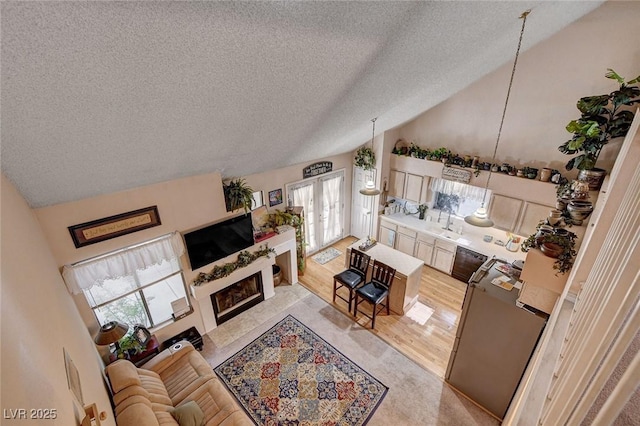 7109 Deepriver Cir, Las Vegas, NV 89129 - living room featuring a textured ceiling, vaulted ceiling, a fireplace, and healthy amount of natural light