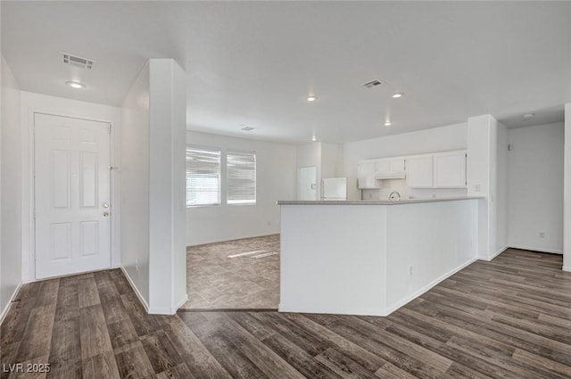 5622 Sage Pines Dr, Las Vegas, NV 89118 - kitchen with freestanding refrigerator, a peninsula, dark wood-type flooring, white cabinets, and baseboards