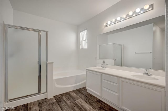 5622 Sage Pines Dr, Las Vegas, NV 89118 - full bathroom featuring a bath, wood finished floors, a stall shower, and double vanity