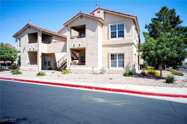 520 Arrowhead Trl Unit 1322, Henderson, NV 89015 - rear view of property featuring stucco siding, a balcony, a tiled roof, and stairway
