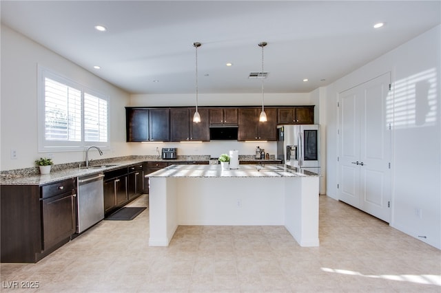 8665 Jerlyn St, Las Vegas, NV 89113 - kitchen featuring stainless steel appliances, a center island, dark brown cabinets, light stone countertops, and recessed lighting