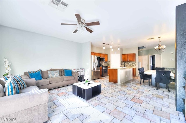6233 Overhang Ave, Henderson, NV 89011 - living room with a ceiling fan, a chandelier, and light stone finish floors