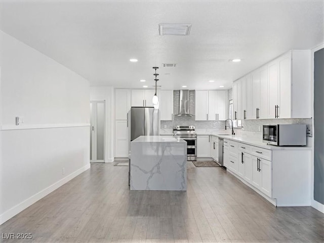 1700 E Oakey Blvd, Las Vegas, NV 89104 - kitchen featuring stainless steel appliances, wall chimney exhaust hood, a sink, a center island, and baseboards