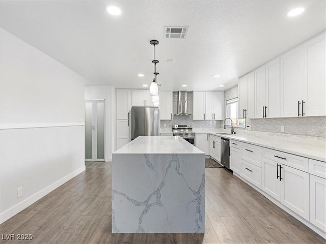 1700 E Oakey Blvd, Las Vegas, NV 89104 - kitchen featuring stainless steel appliances, wall chimney exhaust hood, a sink, a kitchen island, and tasteful backsplash