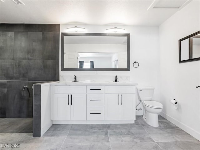 1700 E Oakey Blvd, Las Vegas, NV 89104 - full bath featuring toilet, double vanity, baseboards, a textured ceiling, and a walk in shower