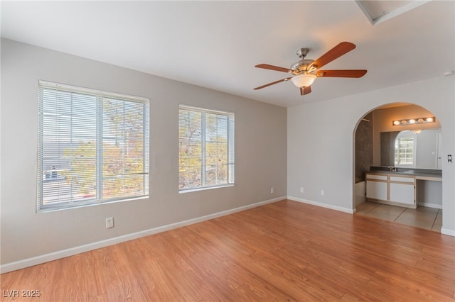 2200 S Fort Apache Rd Unit 2015, Las Vegas, NV 89117 - spare room featuring arched walkways, light wood-type flooring, a ceiling fan, and baseboards