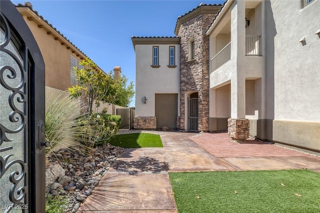 11503 Glowing Sunset Ln, Las Vegas, NV 89135 - exterior space featuring stucco siding, stone siding, a gate, and a tiled roof