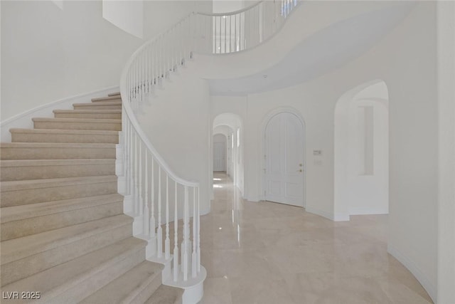 11503 Glowing Sunset Ln, Las Vegas, NV 89135 - staircase featuring arched walkways, a high ceiling, and baseboards