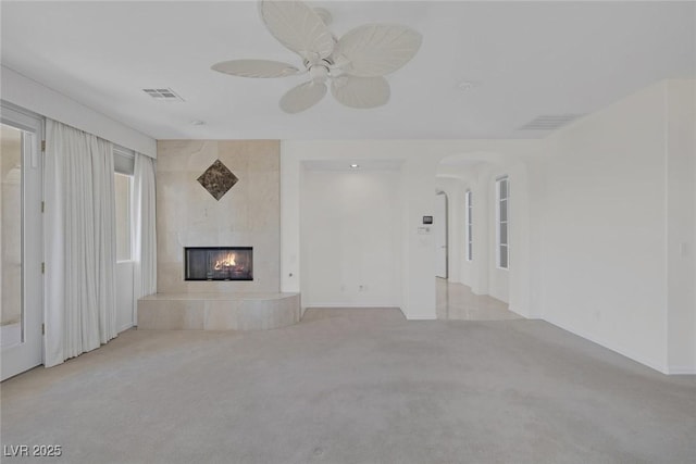 11503 Glowing Sunset Ln, Las Vegas, NV 89135 - unfurnished living room with carpet, a tile fireplace, arched walkways, and ceiling fan