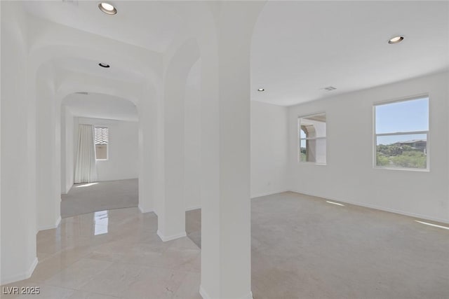 11503 Glowing Sunset Ln, Las Vegas, NV 89135 - hallway featuring arched walkways, healthy amount of natural light, baseboards, recessed lighting, and light marble finish flooring