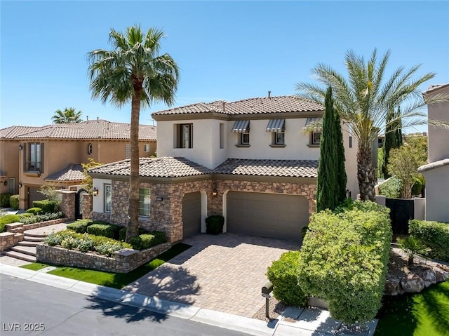 11503 Glowing Sunset Ln, Las Vegas, NV 89135 - mediterranean / spanish house with an attached garage, stucco siding, stone siding, a tiled roof, and decorative driveway