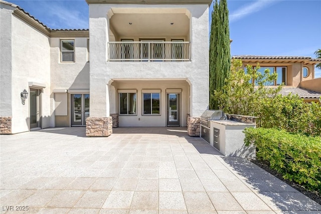 11503 Glowing Sunset Ln, Las Vegas, NV 89135 - back of property featuring area for grilling, stucco siding, a balcony, and a patio