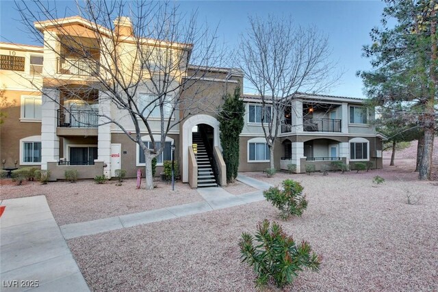 2900 Sunridge Heights Pkwy Unit 518, Henderson, NV 89052 - view of front of house with a balcony, stucco siding, stairs, and a chimney