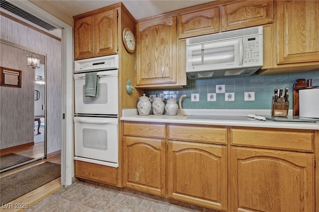 22 Jade Cir, Las Vegas, NV 89106 - kitchen featuring white appliances, light countertops, decorative backsplash, and brown cabinetry