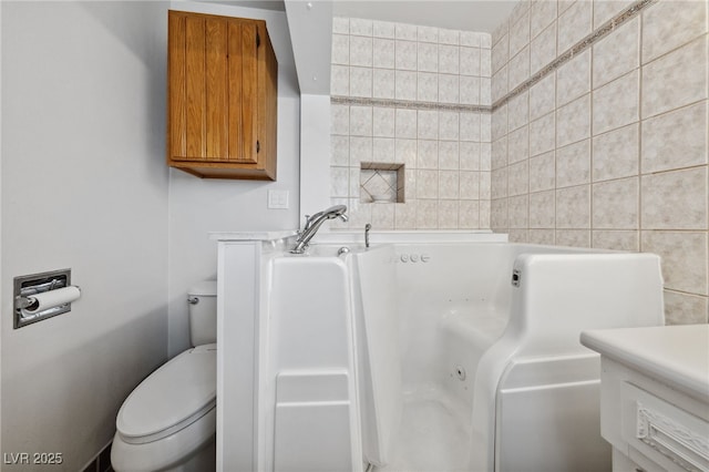 22 Jade Cir, Las Vegas, NV 89106 - bathroom featuring a whirlpool tub, toilet, and tile walls