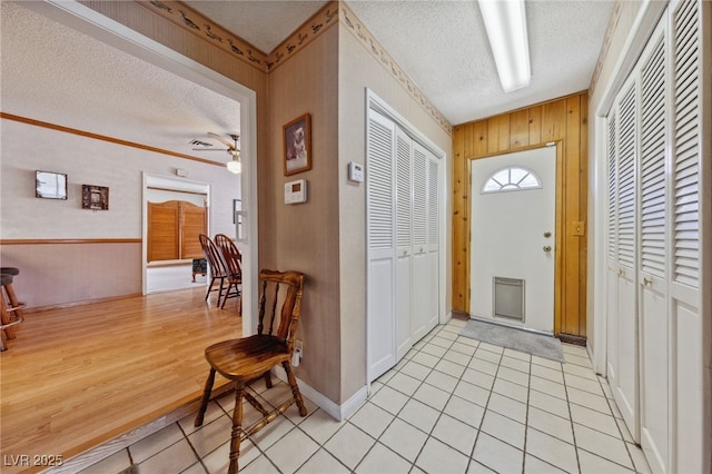 22 Jade Cir, Las Vegas, NV 89106 - foyer featuring a textured ceiling, light tile patterned floors, a ceiling fan, baseboards, and wood walls