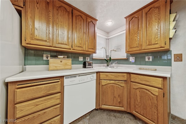 22 Jade Cir, Las Vegas, NV 89106 - kitchen with white dishwasher, backsplash, a sink, light countertops, and brown cabinets