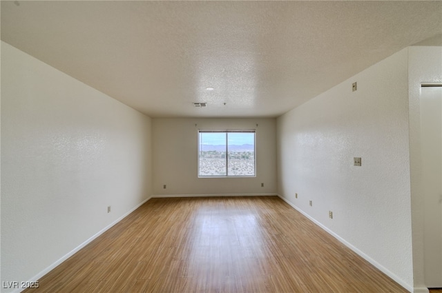 2040 Mesquite Ln Unit 203, Laughlin, NV 89029 - spare room featuring light wood-style flooring, baseboards, and a textured ceiling