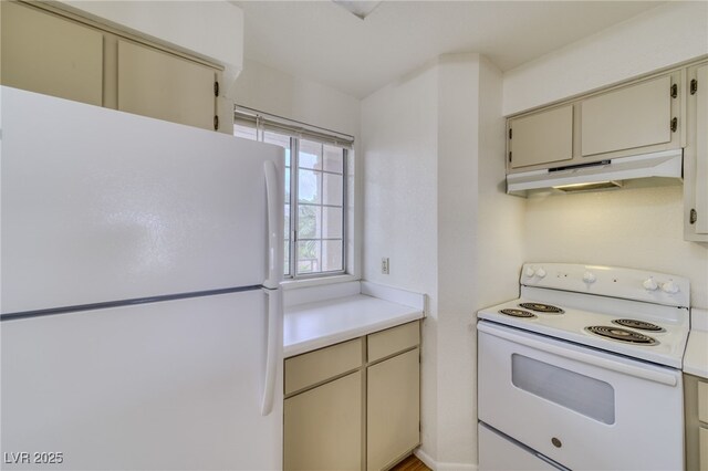 2040 Mesquite Ln Unit 203, Laughlin, NV 89029 - kitchen with white appliances, cream cabinetry, under cabinet range hood, and light countertops